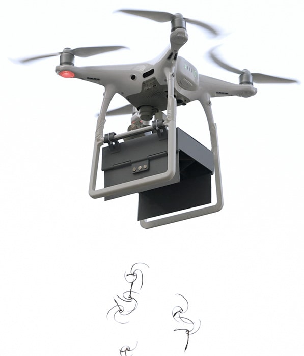 A drone dropping E-Seed Carriers