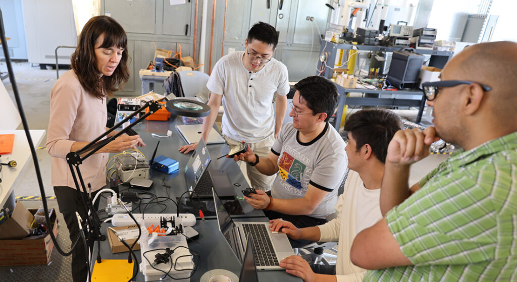 An instructor goes over a lesson with her students in a lab.