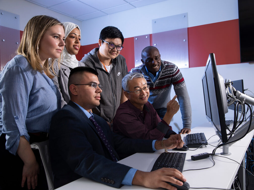 Electrical engineering and computer science professor Kevin Du working with students in Cybersecurity