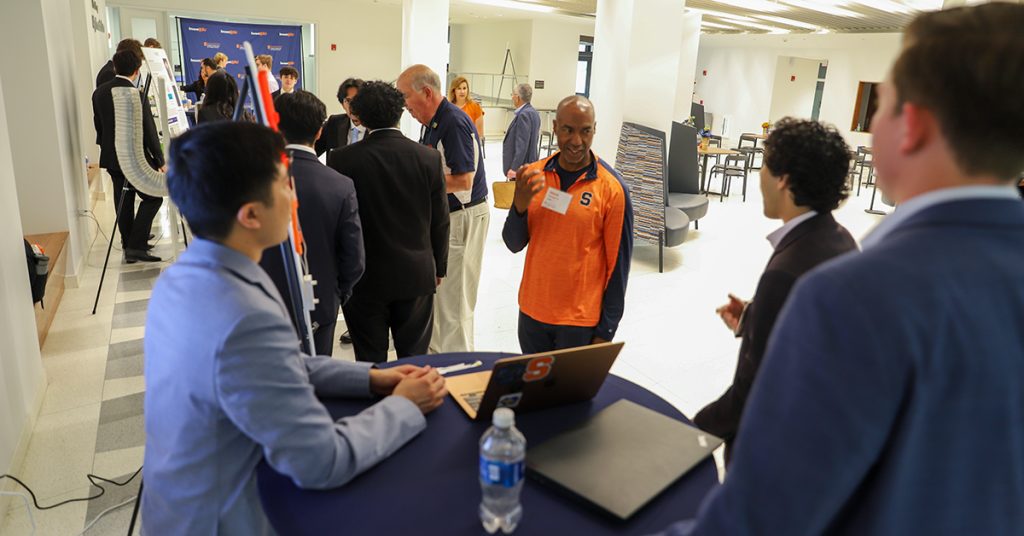 Steve Harvey talking to student inventors in the lobby of Link Hall during the 2025 Invent@SU finals