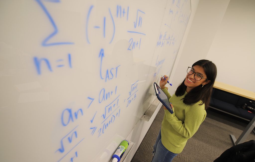 A student working on a math equation during an Academic Excellence Workshop