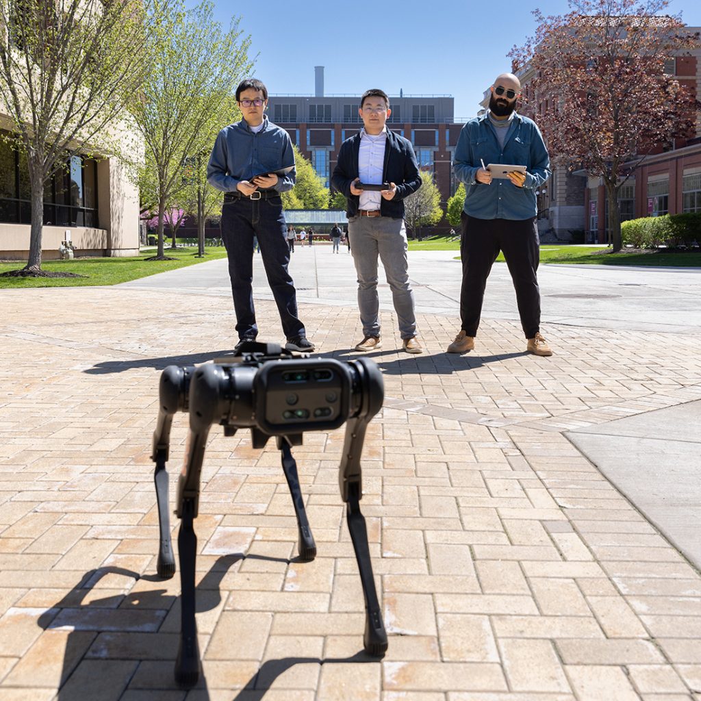 Zhenyu Gan and his team working with robotics outside Link Hall.