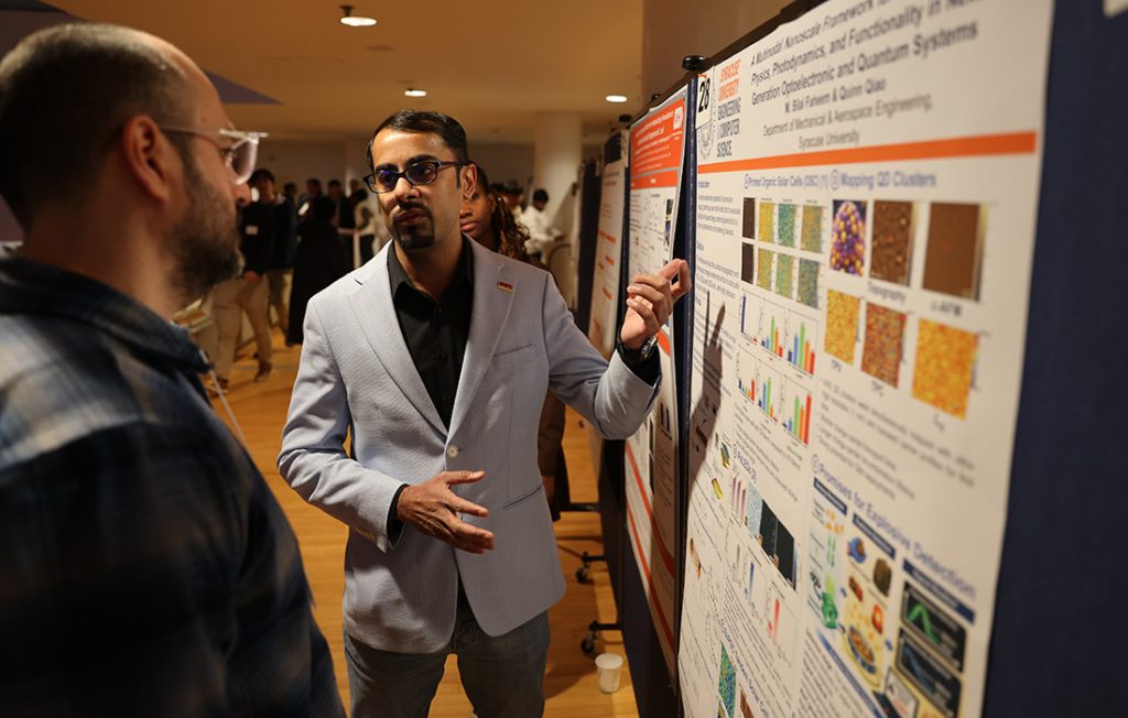 An Engineering and Computer Science student presenting their research during a poster competition