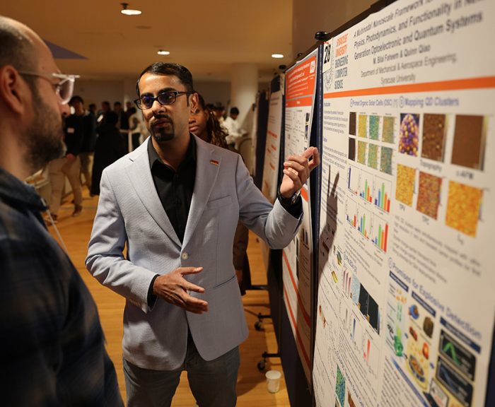 An Engineering and Computer Science student presenting their research during a poster competition