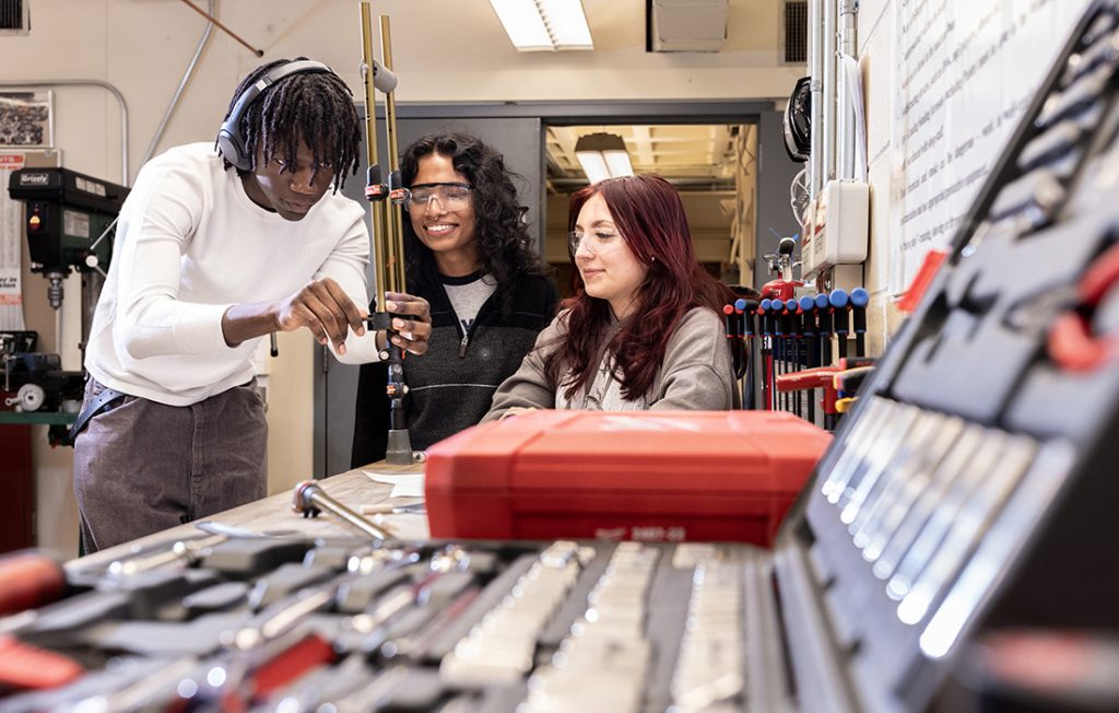 Three students in the Invent@SU program working on a prototype for their invention.