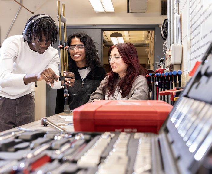 Three students in the Invent@SU program working on a prototype for their invention.