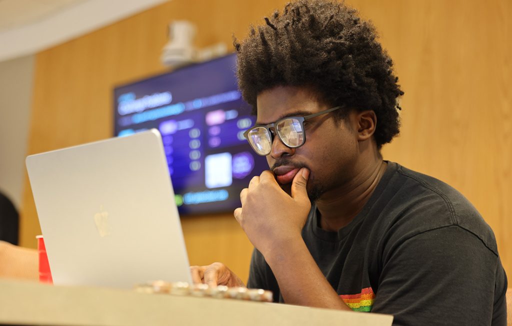 A student working on laptop during a cybersecurity competition 