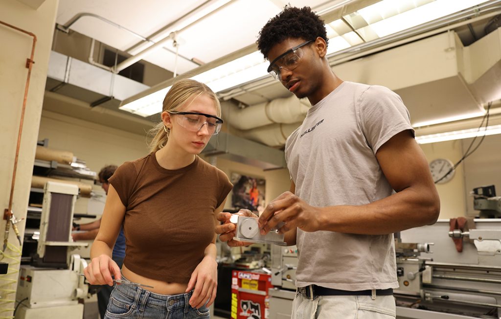 Students inspecting parts for their air engine project