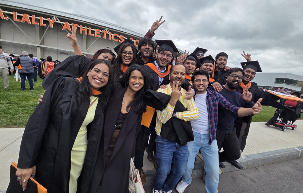 A group of students celebrating with their friends outside of the Engineering and Computer Science Convocation