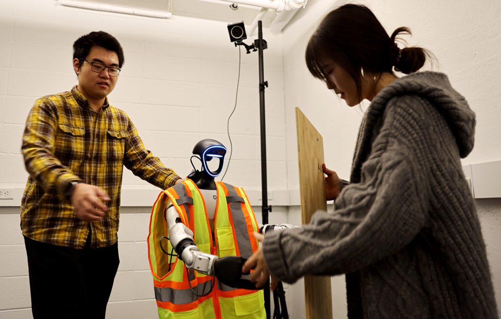 Yizhi Liu and Yanxi Liu with a humanoid construction robot